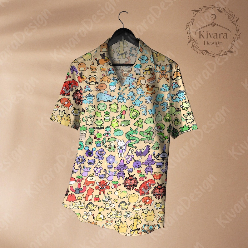May include: Short-sleeved button-down shirt with a beige background and a colorful cartoon character pattern. The shirt is hanging on a black hanger. The shirt features a collared neckline and a relaxed fit.