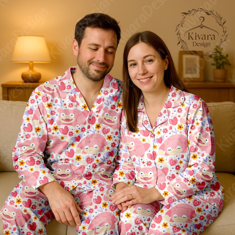 K&ouml;nnte beinhalten: Passender rosa Pyjama mit einer Cartoonfigur, Herzen und floralen Mustern. Der Pyjama hat ein Oberteil mit Kn&ouml;pfen und eine Hose. Das Design umfasst einen wei&szlig;en Hintergrund mit rosa, gelben und blauen Akzenten. Ein Paar tr&auml;gt den Pyjama.