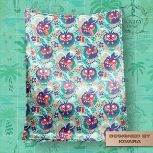 Op de afbeelding: Een patroon deken met een herhalend ontwerp van cartoon monsters met paarse, teal en rode accenten. De monsters hebben grote ogen en tongen, omringd door bloemen en bladeren op een lichtgroene achtergrond. De deken is gelabeld "Designed by KIVARA."