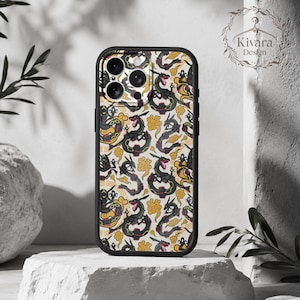 Può includere: Una custodia per smartphone con bordo nero caratterizzata da un motivo ripetuto di creature serpentine nere con accenti rossi, intervallate da motivi a nuvola gialli stilizzati su uno sfondo color crema chiaro. La custodia presenta un ritaglio per tripla fotocamera.