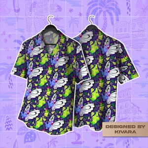 May include: Short-sleeved button-down shirt with a vibrant pattern of white-winged creatures, green figures, and foliage on a dark purple background. The shirt is displayed on a hanger, showcasing both the front and back designs. The text "DESIGNED BY KIVARA" is visible.