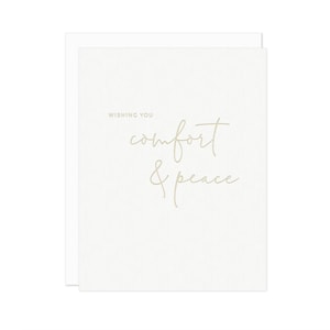May include: A white card with the text "Wishing you comfort & peace" in a light brown font.