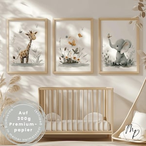 K&ouml;nnte beinhalten: Drei gerahmte Aquarelldrucke mit einer Giraffe, Schmetterlingen und einem Elefanten. Die Drucke befinden sich in hellen Holzrahmen und werden &uuml;ber einem Holzbettchen ausgestellt. Die Drucke haben eine weiche, pastellfarbene Farbpalette.