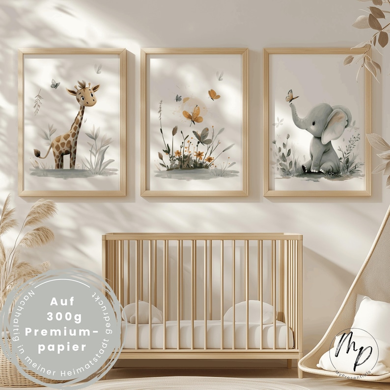 K&ouml;nnte beinhalten: Drei gerahmte Aquarelldrucke mit einer Giraffe, Schmetterlingen und einem Elefanten. Die Drucke befinden sich in hellen Holzrahmen und werden &uuml;ber einem Holzbettchen ausgestellt. Die Drucke haben eine weiche, pastellfarbene Farbpalette.