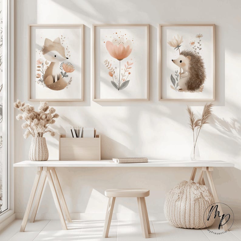 Puede incluir: Tres impresiones enmarcadas en acuarela con animales del bosque y flores. Las impresiones incluyen un zorro, una flor y un erizo. Los marcos son de madera clara y la obra de arte tiene una paleta de colores pastel. Las impresiones se exhiben en un escritorio blanco.