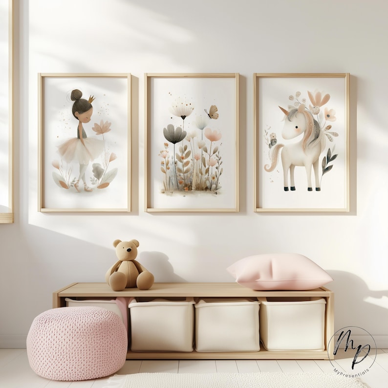 Puede incluir: Tres impresiones enmarcadas en acuarela con una bailarina, flores y un unicornio. Las impresiones tienen marcos de madera clara y se exhiben sobre un banco de almacenamiento de madera con un oso de peluche, una almohada rosa y un puf de punto rosa. La obra de arte tiene una paleta de colores pastel.