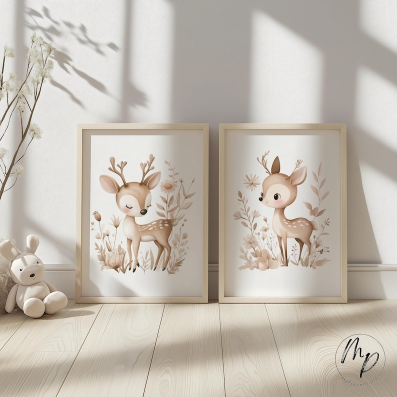 May include: Two framed art prints featuring watercolor illustrations of deer. The deer are depicted in a soft, neutral color palette with floral and botanical elements. The frames are light wood, adding a natural touch to the artwork.