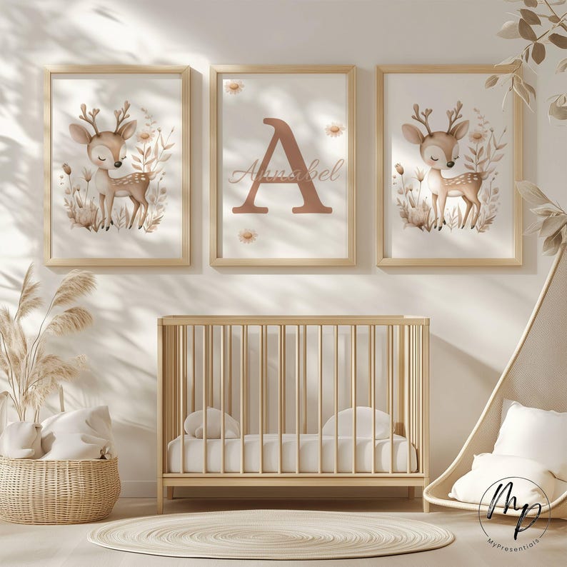 May include: Three framed nursery art prints featuring a watercolor deer illustration and a personalized print with the name "Annabel". The prints are in a light wood frame. A wooden crib, a woven basket, and a round rug complete the nursery decor.