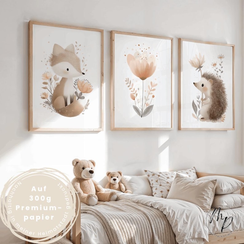 Puede incluir: Tres impresiones enmarcadas en acuarela con animales del bosque y flores. Las impresiones incluyen un zorro, una flor y un erizo. Los marcos son de madera clara. Las impresiones se exhiben sobre una cama con osos de peluche y almohadas.