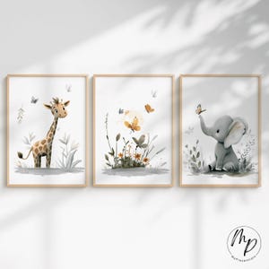 K&ouml;nnte beinhalten: Set aus drei gerahmten Aquarelldrucken mit einer Giraffe, Schmetterlingen und einem Elefanten. Die Giraffe hat braune Flecken, die Schmetterlinge sind orange und gelb, und der Elefant ist grau. Die Rahmen sind aus hellem Holz.