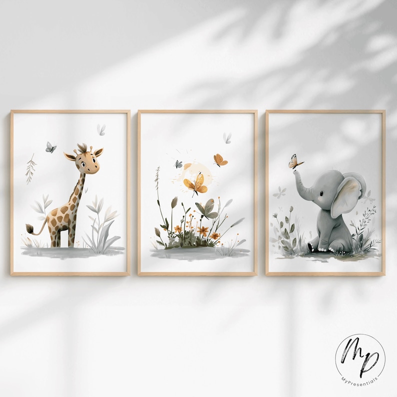 K&ouml;nnte beinhalten: Set aus drei gerahmten Aquarelldrucken mit einer Giraffe, Schmetterlingen und einem Elefanten. Die Giraffe hat braune Flecken, die Schmetterlinge sind orange und gelb, und der Elefant ist grau. Die Rahmen sind aus hellem Holz.