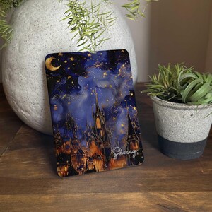 May include: A rectangular, decorative item featuring a night sky design with a crescent moon, stars, and a castle silhouette. The artwork is in shades of blue, gold, and orange, with the name "Sherry" in cursive script.