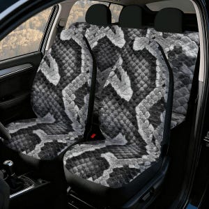 Op de afbeelding: Autostoelhoezen met een zwart, wit en grijs slangenpatroon. De hoezen zijn ontworpen voor de voor- en achterstoelen van een voertuig. Het slangenpatroon is een herhalend patroon dat het hele oppervlak bedekt.