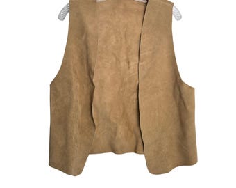 May include: A tan-colored vest made of a suede-like material hangs on a clear plastic hanger. The vest has a sleeveless design with a V-neck and a straight hemline. The vest is open in the front.