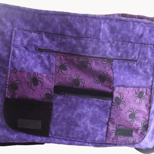May include: Purple patchwork messenger bag with a spiderweb pattern and multiple zippered pockets.