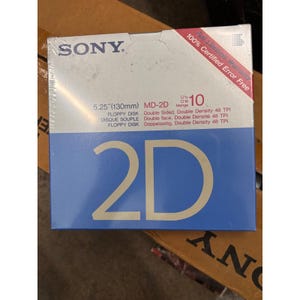 May include: A sealed box of ten Sony 5.25 inch floppy disks. The white and blue packaging features the text Sony, MD-2D, 2D, and 100% Certified Error Free. The box indicates the disks are double sided and double density with 48 TPI capacity.