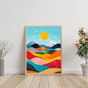 Peut inclure: Une peinture abstraite de paysage encadrée avec un soleil jaune vif dans un ciel bleu. Le paysage est composé de collines colorées dans des tons de rouge, orange, jaune, vert, bleu et rose.