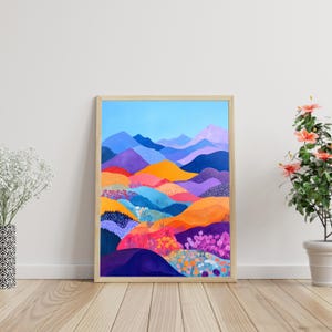 Peut inclure: Une peinture abstraite encadrée d'un paysage coloré avec des collines violettes, bleues, orange et jaunes. Les collines sont recouvertes de petites fleurs colorées. Le fond est un ciel bleu clair.