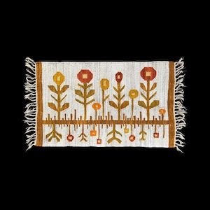 May include: A rectangular, off-white woven rug with a floral pattern. The flowers are in shades of yellow, orange, and red, with brown stems and a brown border. The rug has fringed edges.