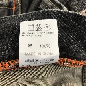 May include: Close-up of a denim garment label. The label displays washing instructions, including a 40-degree wash symbol. The text on the label reads "100% Cotton" and "Made in China."