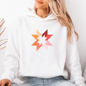 May include: White hooded sweatshirt with a starburst design in red, orange, and pink hues. The hoodie has a front pocket and a drawstring hood. A casual and comfortable item of clothing.