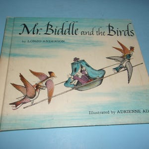 May include: A vintage children's book titled "Mr. Biddle and the Birds" by Lonzo Anderson, illustrated by Adrienne Adams. The cover features an illustration of birds pulling a carriage with a person inside. The book has a light blue background.