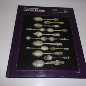 May include: A hardcover book titled "The Encyclopedia of Collectibles" with a purple cover. The book's cover features a black background with various antique spoons displayed. The word "spoons" is visible at the bottom right.