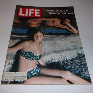May include: A vintage LIFE magazine cover featuring a woman in a blue floral bikini and a man. The headline reads "YOUNG AMERICAN NOMADS ABROAD." The cover also includes the date "JULY 19, 1968."