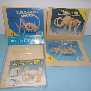 May include: Four boxed craft kits: "Build-A-Bug Cricket", "Mammoth Build Your Own Dinosaur", "Build-A-Bug Ant", and "Build-A-Furniture Dining Room Kit". The kits feature wooden pieces and colorful packaging with product illustrations. The kits are for ages 6 and up.