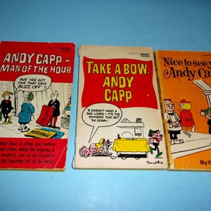 May include: Three vintage Andy Capp comic books. The covers are red, white, and orange, with illustrations of characters and text. Titles include "Andy Capp - Man of the Hour," "Take a Bow, Andy Capp," and "Nice to see you, Andy Capp!"