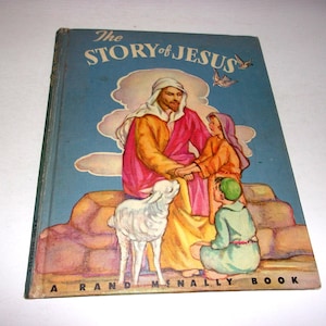 May include: Vintage children's book titled "The Story of Jesus" by Rand McNally. The cover features an illustration of Jesus with two figures and a lamb, set against a blue sky background. The book has a worn appearance.