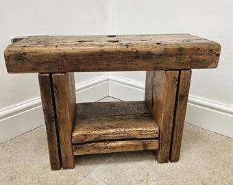 A vintage rustic console bench crafted from aged reclaimed beams.
