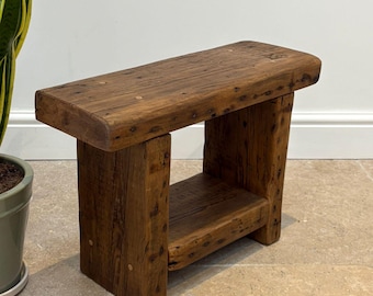 A vintage rustic console bench crafted from aged reclaimed beams.