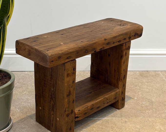 A vintage rustic console bench crafted from aged reclaimed beams.