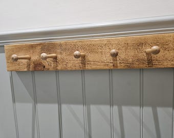 A handmade versatile rustic coat rack with peg hooks.