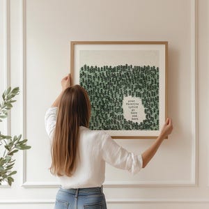 May include: A framed art print with a forest design in green and white. The artwork includes the text "your favourite lyrics go here and here" in a white cutout. The frame is a light brown colour.