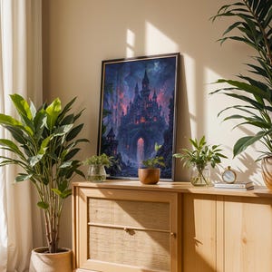 May include: A framed art print of a fantasy castle scene with a dark, gothic aesthetic. The artwork features a towering castle with multiple spires, set against a dramatic, colourful sky. The print is displayed on a wooden cabinet with plants.