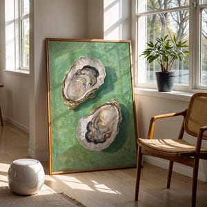 Op de afbeelding: Een schilderij van twee oesterschelpen op een groene achtergrond. De schelpen zijn open en laten de binnenkant van de oester zien. Het schilderij is ingelijst in een houten lijst.