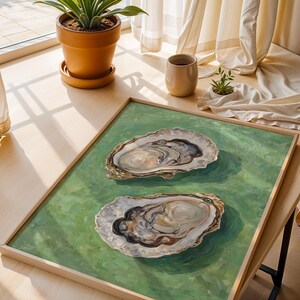 Op de afbeelding: Een ingelijst schilderij van twee oesterschelpen op een groene achtergrond. De schelpen zijn open en laten de binnenkant van de oester zien.