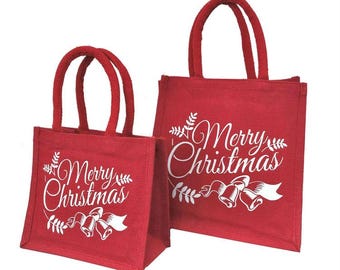 Könnte beinhalten: Zwei rote Jute-Tragetaschen mit passenden roten Griffen. Die Taschen tragen in weißer Schrift den Schriftzug "Merry Christmas" sowie weiße Glocken- und Schleifenmotive. Ideal für Weihnachtsgeschenke.