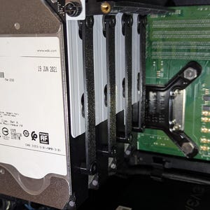 Può includere: Primo piano dei componenti interni di un computer, tra cui un disco rigido Western Digital da 8 TB e una scheda a circuito stampato verde. L'hard disk è montato in un telaio nero con divisori argentati. La data "19 JUN 2021" è visibile.