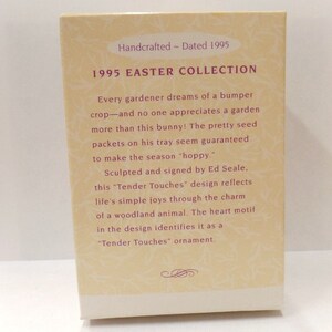以下が含まれることがあります： 「1995 EASTER COLLECTION」と書かれたクリーム色の箱。テキストはウサギと種子のパックについて説明しています。箱には「Handcrafted - Dated 1995」と書かれており、Ed Sealeによって署名されています。