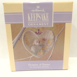 May include: Hallmark Keepsake Ornament, Promise of Easter, featuring a white lamb in a heart-shaped frame with floral details. For decorative use only.