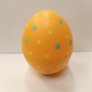 May include: A yellow plastic Easter egg with a polka dot pattern in yellow and blue.