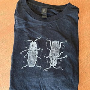 May include: A handmade wooden sign with the text "Welcome" in a playful font. The sign features a distressed white background and a dark stained wooden frame. A small, decorative heart is attached to the sign.