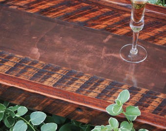 May include: A wooden serving tray with a brown leather insert. The tray has a rustic, reclaimed wood look with a dark brown stain. A glass of champagne sits on the tray.