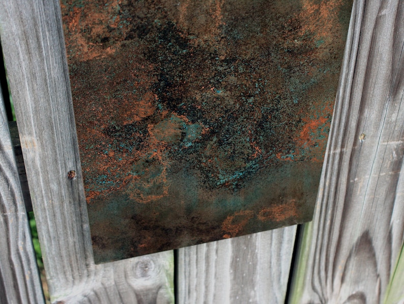 May include: A close-up of a textured metal sheet with a mottled green and copper finish. The surface has a rustic, aged look.