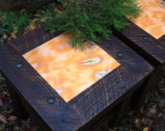 May include: Two rustic wooden side tables with copper tops. The copper has a unique, iridescent finish with shades of orange, blue, and green. The tables have dark wood frames with metal accents.