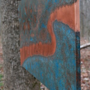 May include: A large, rectangular metal panel with a blue and copper patina. The panel has a unique, abstract design with a flowing, organic shape.