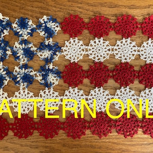 May include: A crochet pattern for an American flag made with red, white, and blue yarn. The pattern is made up of small circles, each with a different color. The text "PATTERN ONLY" is printed on the image.